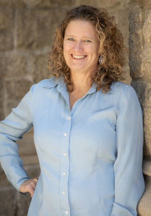 Heather McKelvey leaning against a wall with hand on hip