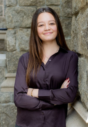 Karly Petersen leaning up agian a brick wall.