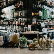 A bar with liquor and wine on shelfs.