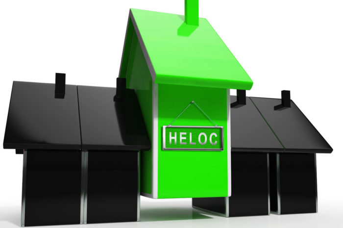 Green house in 3D with HELOC written on it next to two black 3D houses concept for Home Equity Line Of Credit.
