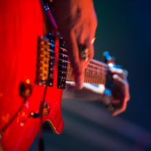 Close up of a person playing a guitar.