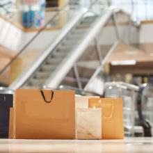 Shopping mall with shopping bags in front of escalator